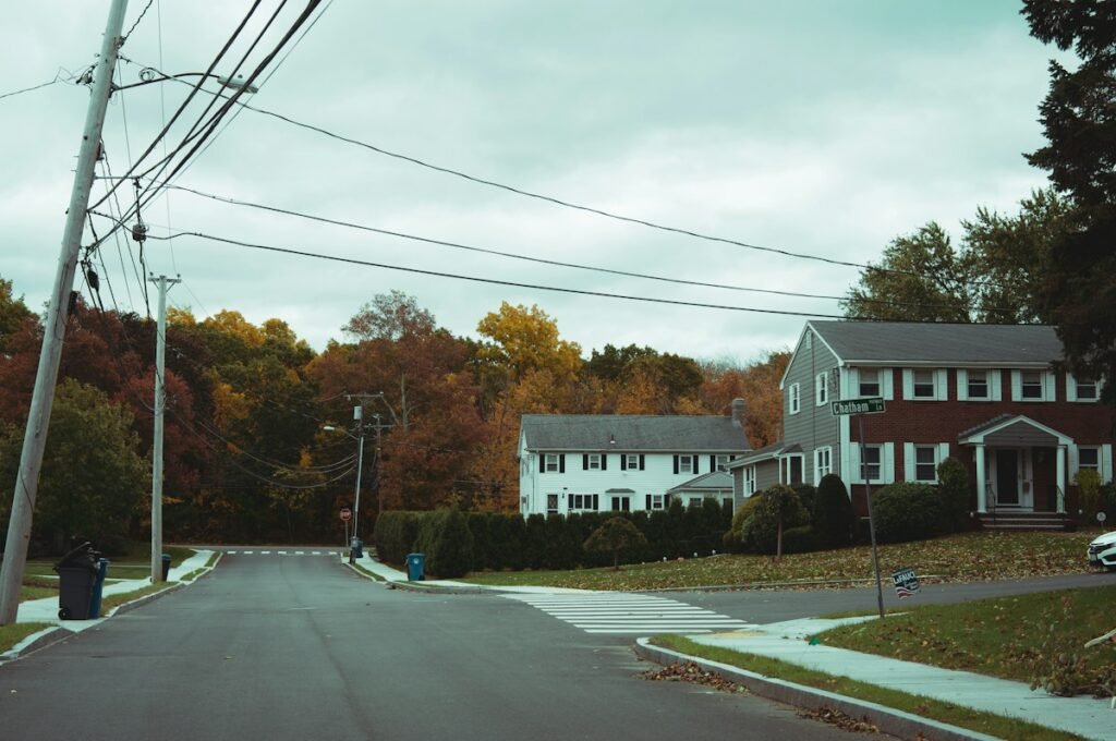 Residential street lined with houses and autumn trees in an American suburb